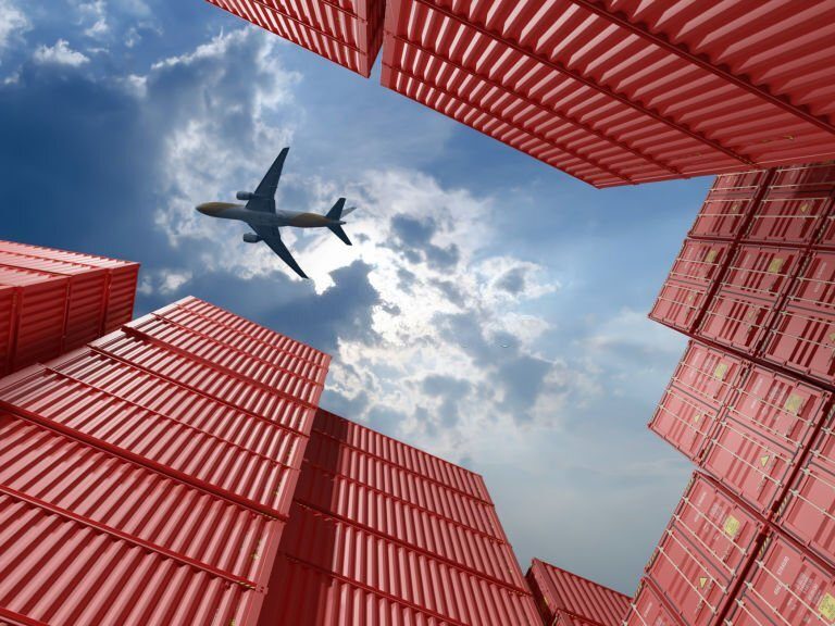 Plane above a container in a warehouse.